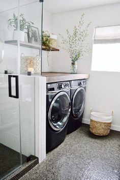 a washer and dryer in a room with glass doors on the wall, next to a window