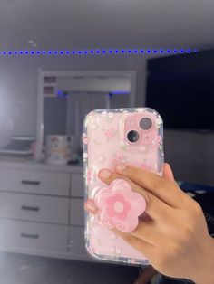 a person holding up a phone case with a pink flower on the front and bottom