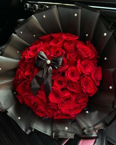 a bouquet of red roses in the back of a car