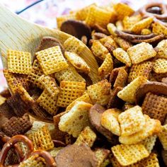 a wooden spoon filled with cheetos and pretzels