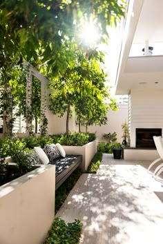 an outdoor living area with white furniture and trees