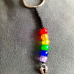 a keychain with a rainbow bead and a skull charm hanging from it