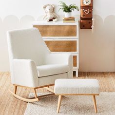 a white rocking chair and foot stool in a child's room with a clock on the wall