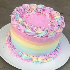 there is a cake that has been decorated with pastel colors and sprinkles