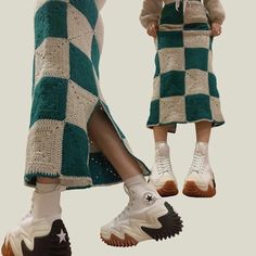 two people wearing green and white checkered knitted skirts, one with high heels