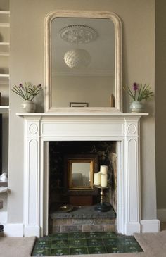 a living room with a fire place and mirror