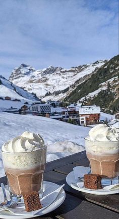 two cups filled with ice cream sitting on top of a table next to each other