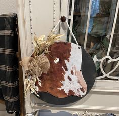 a cow hide hanging on the side of a door with some dried flowers in it