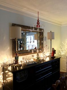 a room with christmas lights on the wall and a mirror in the corner above it