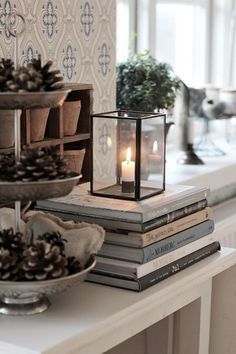 a table topped with lots of books and a lit candle on top of each book