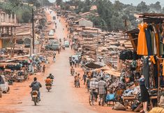 there are many people riding motorcycles down the street in this town that is full of shops