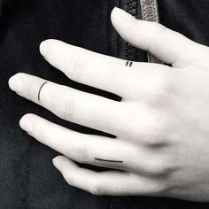 a person's left hand with two rings on their fingers and one ring in the middle