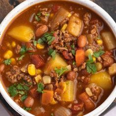 a white bowl filled with chili and corn soup on top of a wooden cutting board