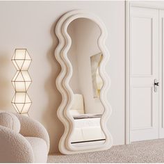 a large white mirror sitting on top of a wall next to a chair and lamp