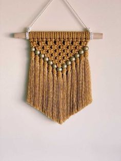 a macrame wall hanging with wooden beads and tassels