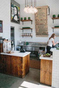 a woman is standing at the counter in a coffee shop with lots of menus hanging on the wall