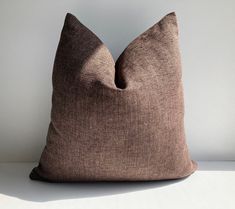 a brown pillow sitting on top of a white table