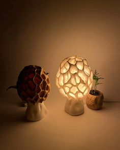 two lamps sitting on top of each other next to a potted plant in a vase