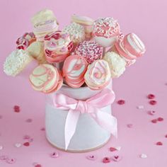 a vase filled with lots of pink and white cookies