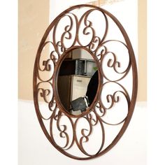 a round metal mirror hanging on the wall