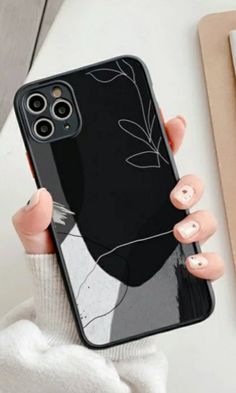 a woman holding up her phone case with an image of a cat on the back