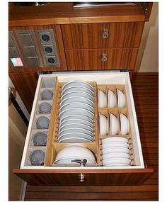 an open drawer with dishes in it