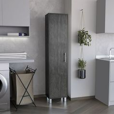 a washer and dryer in a room next to each other with plants hanging on the wall