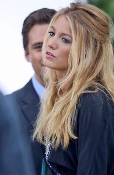 a woman with long blonde hair standing next to a man