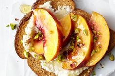 an open face sandwich with peaches and whipped cream on toasted bread, topped with pistachio