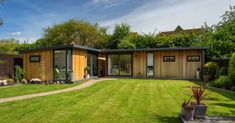 a modern house in the middle of a lush green yard