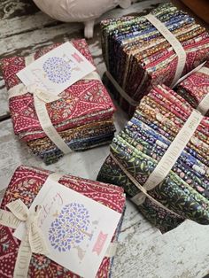 several pieces of colorful fabric sitting on top of a wooden table next to each other