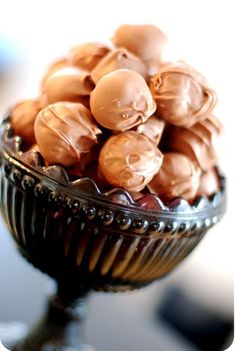 a glass bowl filled with chocolate candies on top of a table