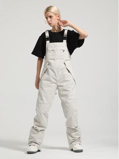 a woman in white overalls and black shirt