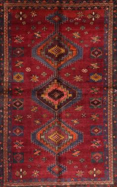 a red rug with an intricate design on the front and side, in different colors