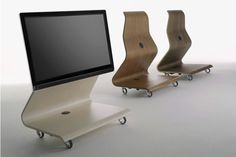 three wooden chairs and a computer monitor on wheels