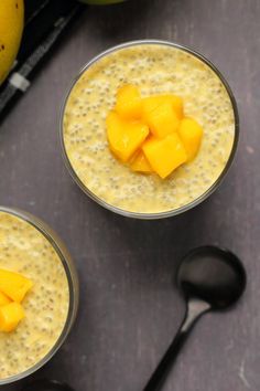 two glasses filled with mango smoothie on top of a table