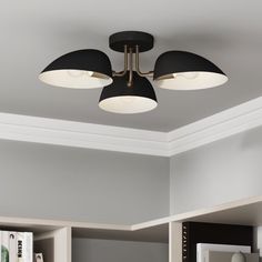 a ceiling light with three black shades on the top and two white lights above it