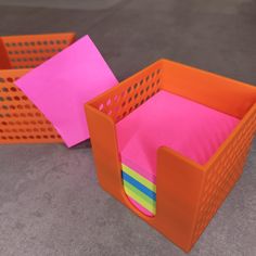 two orange bins with pink and yellow sticky notes in them, one is empty