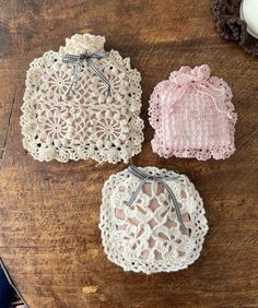 three crocheted doily sitting on top of a wooden table