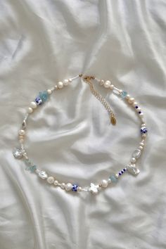 this necklace is inspired by the dreamy and exciting island of Mykonos; where the azure Aegean Sea meets white-washed architecture. each element is thoughtfully chosen to capture the essence of Mykonos--the blue and white color palette, keshi pearls to mirror the island's natural beauty and architectural uniqueness, and aquamarine gemstone chips infuse the design with a sense of tranquility and serenity. handmade with:  baroque, keshi and freshwater pearls 14k gold filled beads aquamarine gemstone chips painted ceramic beads Czech glass seed beads 14k gold or sterling silver lobster clasp 14k gold or sterling silver 2'' extension chain please note: no two necklaces are exactly the same--pearls and certain organic materials bear no symmetrical constraints; with subtle variations in color, s Blue And White Color Palette, White Color Palette, Sea Jewelry, Two Necklaces, Gemstone Necklaces, Aegean Sea, Keshi Pearls, Aquamarine Gemstone, Pearl Gemstone