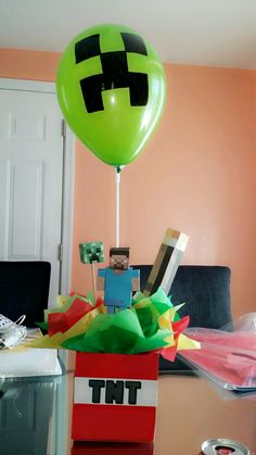 a balloon that is in the shape of a minecraft creeper on top of a box