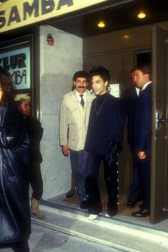 three men standing in the doorway of a building