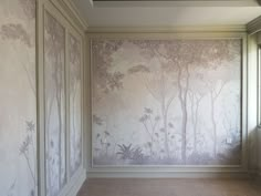 an empty room with wallpapered walls and flooring in front of a window