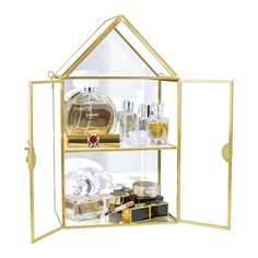 a gold shelf with bottles and perfumes in it on top of a white background