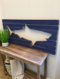 a wooden bench with a shark cut out on the side and a potted plant next to it