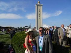 two people standing next to each other in front of a tall white sign with the word finish on it