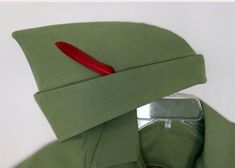 a close up of a green shirt with a red patch on the chest and collar