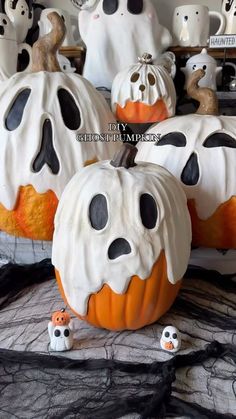 halloween pumpkins decorated with black and white icing, ghost faces and heads on top