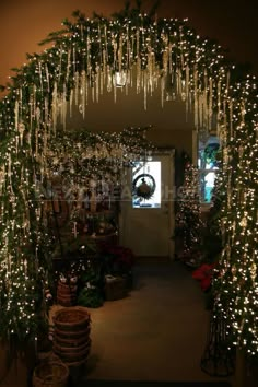 an archway decorated with christmas lights and greenery