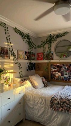 a bed room with a neatly made bed and lots of plants on the wall above it